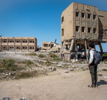 A Student From The City Of Taiz, Yemen Looks At The Rubble Of His School