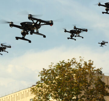 Concept Image Of A Swarm Of Quadcopter Drones In The Air Over A City