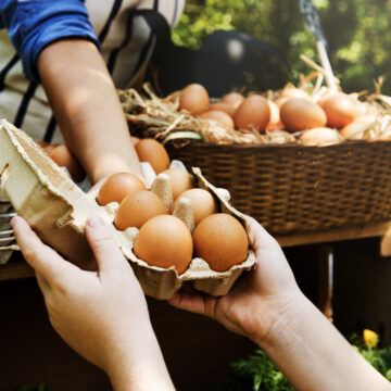 A Woman Selling Fresh Chicken Eggs At A Local Farmer Market
