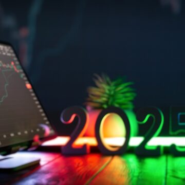 A Laptop With Stock Graphs, Colorful Lights In The Background, And A "2025" Sign