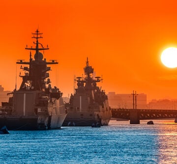 A Caravan Of Naval Warships Against The Background Of A Setting Sun
