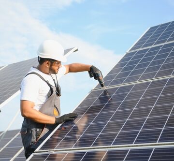 An Indian Worker In Uniform With Tools Working On Solar Panels