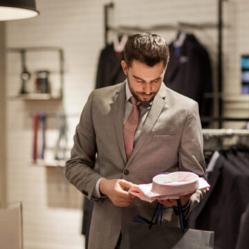 Elegant Gentleman Examining Fine Clothing In An Upscale Boutique