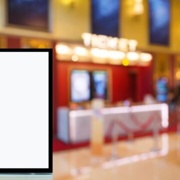 A Blank Movie Poster Frame In A Movie Theater Lobby With A Empty Ticket Counter In The Background