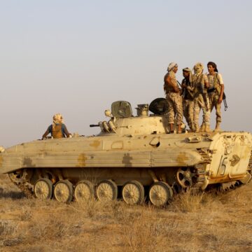 Soldiers With An Armored Personnel Carrier In The Desert