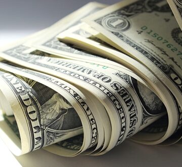 A Close-up Image Of A Rolled-Up Stack Of One-Dollar Bills