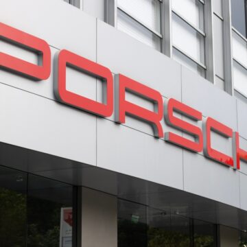 The Prominent Red "PORSCHE" Logo On The Exterior Of A Porsche Dealership Or Corporate Office