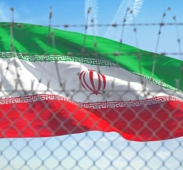 The Flag Of Iran Behind A Barbed Wire Fence