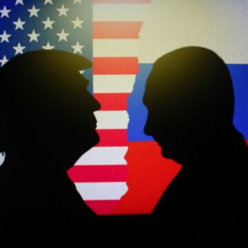 Silhouettes Of Donald Trump And Vladimir Putin Facing Each Other With The U.S. And Russian Flags In The Background