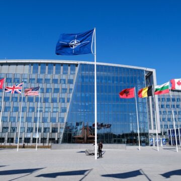 NATO Headquarters In Brussels, Belgium, With The Flags Of Its Member Nations And The NATO Flag Flying Prominently