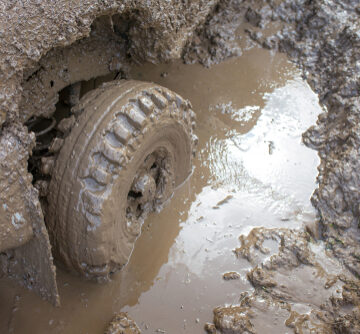 Image Shows A Car Tire Deeply Stuck In Mud