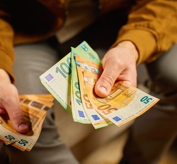 A Person Counting A Stack Of Euro Banknotes At Home