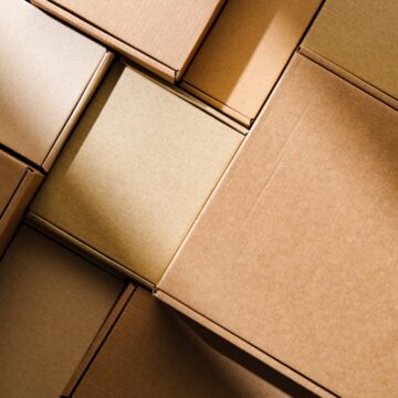 Wall-To-Wall Stacked Cardboard Boxes Arranged In An Orderly Pattern