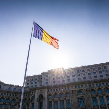 The Romanian Flag Flying In Front Of The Parliament of Romania Located In The Capital City Of Bucharest