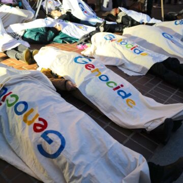 Human Rights Activists Hold A "Die-In" Protest In San Francisco, CA, Where Individuals Are Covered In White Sheets Resembling Body Bags With The Word "Genocide" Written On Them In Google Logo Style