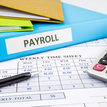 Image Shows A Weekly Timesheet For Payroll, Along With A Calculator And A Folder Labeled "PAYROLL"