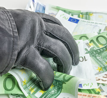 A Black Leather-Gloved Hand Grabbing A Handful Of Euros
