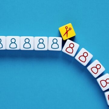 Downsizing Concept Showing Figure-Labeled Cubes Separated By A Pair Of Scissors