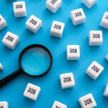 Image Depicts A Magnifying Glass Hovering Over Numerous White Blocks, Each Labeled With The Word "JOB," Against A Blue Background