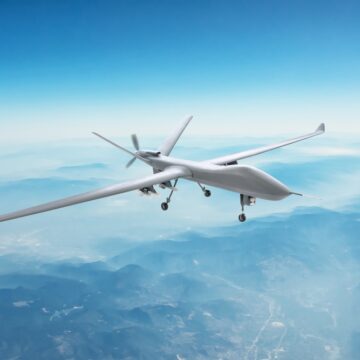 An Unmanned Spy Military Drone Flies Over Mountains At Daytime