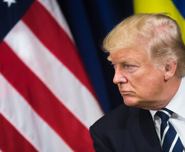 U.S. President Sitting In Front Of The U.S. And Ukrainian Flags