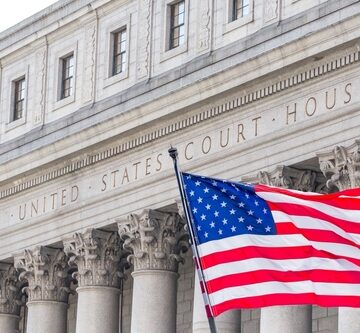 U.S. Flag Waving In Front Of A U.S. Court House