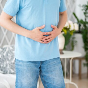 A Young Man Holding His Stomach In Obvious Distress