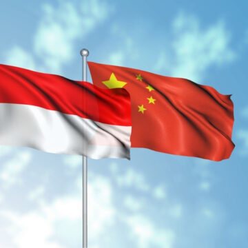 Image Displays The National Flags Of Indonesia (left) And The People's Republic Of China (right) Flying Together Against A Cloudy Blue Sky