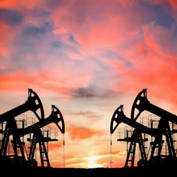 Silhouettes Of Crude Oil Pumpjacks Against A Brilliant Pink Sunset