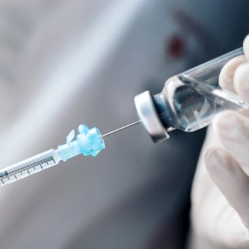 Image Shows A Medical Professional In Gloves Drawing Liquid Medication From A Vial Into A Syringe For Injection