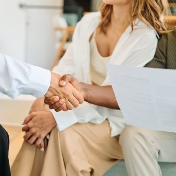 An Agreement Being Sealed With A Handshake Between A Couple And An Agent Or Advisor