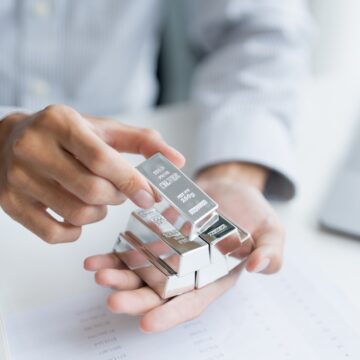 A Person Holding Several Silver Bullion Bars, Typically Stamped As .999 Fine Purity And With Their Weight