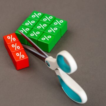 Concept Illustration Showing Scissors Cutting Off A Section Of Red Blocks From Green Blocks With Percentage Symbols Representing Interest Rate Cuts