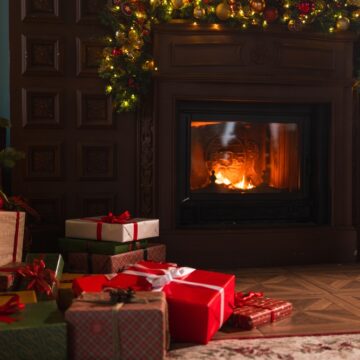 Classic Christmas Setting Of Decorated Living Room With Fireplace, Christmas Tree, And Wrapped Presents