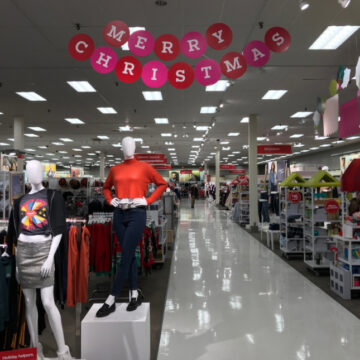 A Nearly-empty Retail Store Interior Decorated For The Christmas Season With A Large "MERRY CHRISTMAS" Sign Hanging From The Ceiling