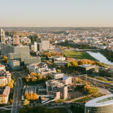 An Aerial Panorama Of The City Of Vilnius, The Capital Of Lithuania, Showing The Modern Central Business District Alongside Green Spaces And The Neris River