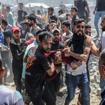 Palestinian Men In The Gaza Strip Transporting An Injured Or Dead Person From The Site Of Destruction Following An Israeli Airstrike