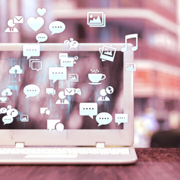 Conceptual Illustration Of Digital Marketing And Social Media Engagement, Showing A Laptop Surrounded By Various Communication And Media Icons