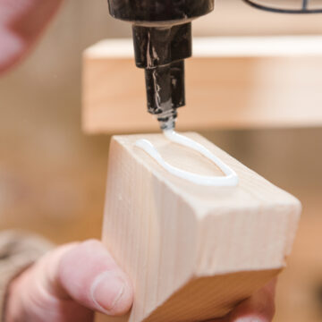 A,Man,Squeezes,The,Glue,On,The,Wooden,Part.,Carpentry USED COOKING OIL PRODUCES GLUE STRONG ENOUGH TO TOW A CAR