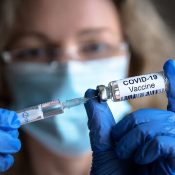 A Female Healthcare Worker Preparing A COVID-19 Vaccine