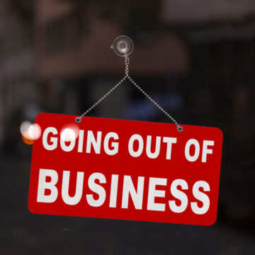Close-up Of A Red Sign In The Window Of A Store That Reads "Going Out Of Business"