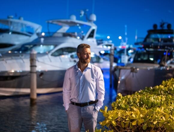 A Wealthy Well-dressed Man Standing At A Marina Next To Several Large Yachts At Night A Wealthy Well-dressed Man Standing At A Marina Next To Several Large Yachts At Night
