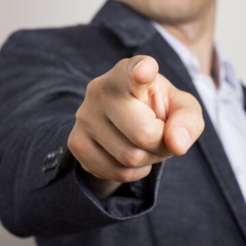 Photo of a man in a business suit pointing his index finger directly toward the viewer. Photo of a man in a business suit pointing his index finger directly toward the viewer.