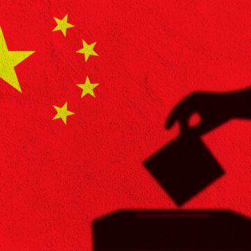 An image of the national flag of China with the silhouette of a hand dropping a ballot into a ballot box in the foreground.