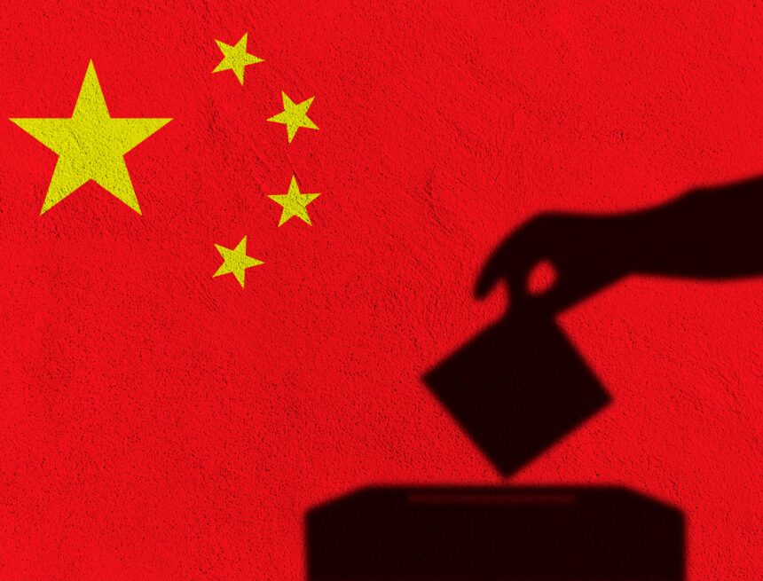 An image of the national flag of China with the silhouette of a hand dropping a ballot into a ballot box in the foreground. An image of the national flag of China with the silhouette of a hand dropping a ballot into a ballot box in the foreground.