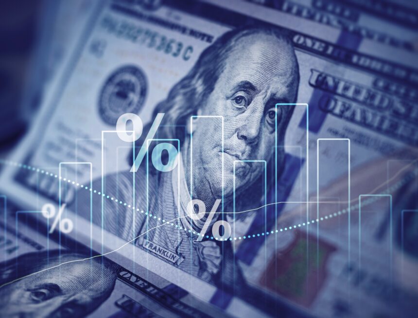 Digital image of U.S. dollar bills overlaid financial data symbols such as bar graphs and percentage symbols.