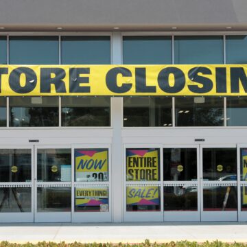 A retail storefront displaying multiple "Store Closing" and liquidation sale signs in Lake,Forest, California.