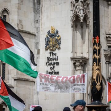 Pro-Palestinian activists protest with Palestinian flags outside the Royal Courts in London, UK.