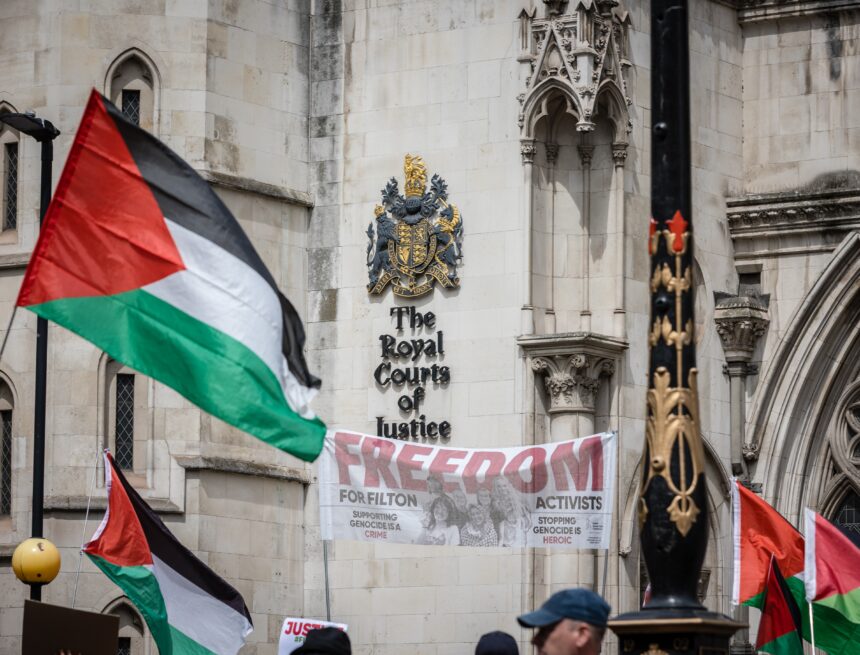 Pro-Palestinian activists protest with Palestinian flags outside the Royal Courts in London, UK. Pro-Palestinian activists protest with Palestinian flags outside the Royal Courts in London, UK.