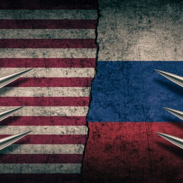 Sharp silver missiles lined up on either side of the flags of the United States and Russia. Sharp silver missiles lined up on either side of the flags of the United States and Russia.